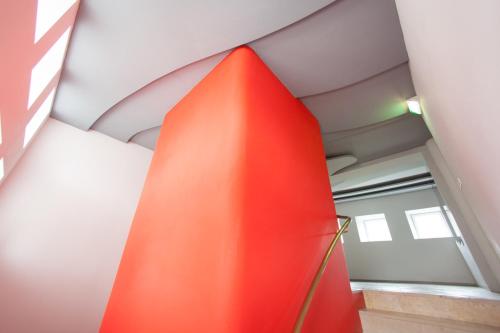 a red wall in a room with a ceiling at Rotel Inn in Passau