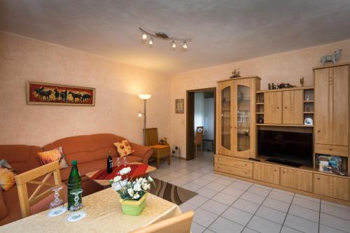 a living room with a couch and a television at Gästehaus Bautz in Enkirch