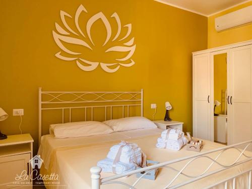 1 dormitorio con 1 cama con una gran flor en la pared en La Casetta en SantʼEufemia Lamezia