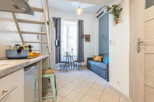 Il comprend une cuisine et un salon doté d'un canapé bleu. dans l'établissement MY CASA - SAINT SIAGRE 1, à Nice