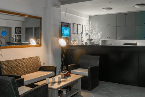 Una sala de estar con sillas y una mesa y una cocina. en Marie Κelly Apartments, en Gouves