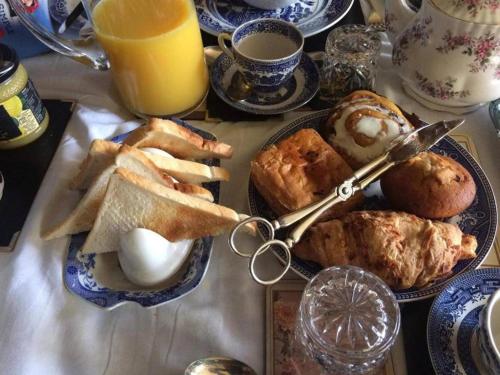 una mesa de desayuno con un montón de alimentos para el desayuno y zumo de naranja en Ms McCreadys Guest House, en Doncaster