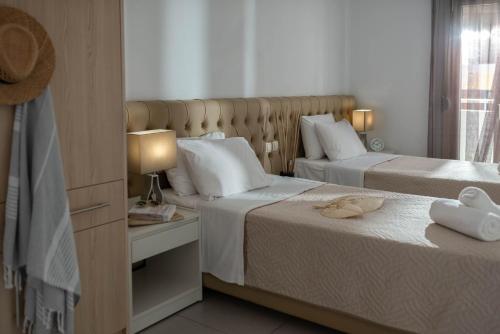 Una habitación de hotel con dos camas y una ventana. en Marie Κelly Apartments, en Gouves