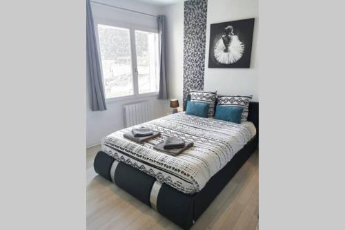 une chambre avec un lit avec des oreillers bleus et une fenêtre dans l'établissement L'INDUSTRIAL - 500m Musée BD, à Angoulême