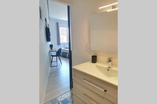 une salle de bain avec un lavabo et un miroir dans l'établissement L'INDUSTRIAL - 500m Musée BD, à Angoulême