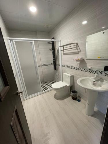 uma casa de banho com um chuveiro, um WC e um lavatório. em Toon Bud Homestay em Yuli