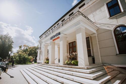 a white building with steps in front of it at Hotel Cēsis in Cēsis