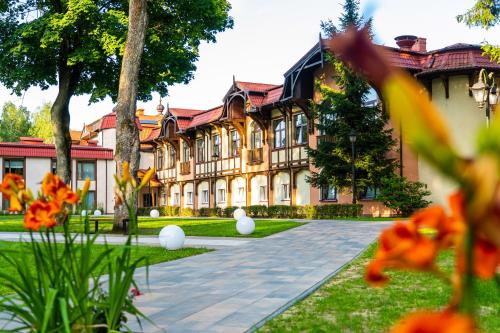 an old building with orange flowers in front of it at Hotel Anders in Stare Jabłonki