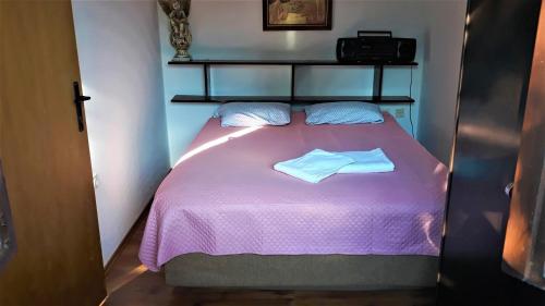 um pequeno quarto com uma cama roxa com duas toalhas em Apartment Modric em Senj