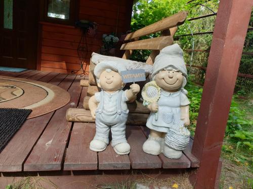 a group of three figurines sitting on a deck at Brązowy Domek - Tleń, Bory Tucholskie in Tleń