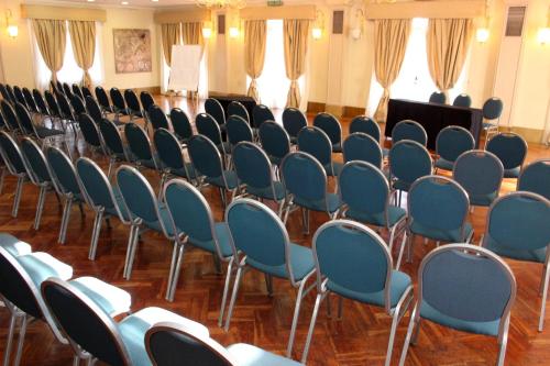 a row of chairs in a room with a stage at Hotel Colonial San Nicolás in San Nicolás de los Arroyos