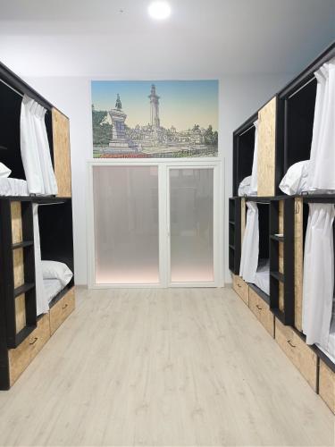 a room with two bunk beds and a large window at Planeta Cadiz Hostel in Cádiz
