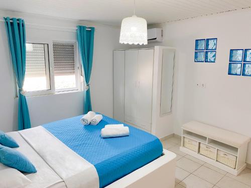 - une chambre bleue et blanche avec des serviettes sur un lit dans l'établissement Carpe Diem Studios, à Ialyssos