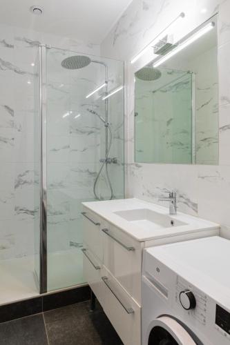 une salle de bain avec une douche en verre et un lavabo dans l'établissement DIFY Castries Quartier Ainay, à Lyon