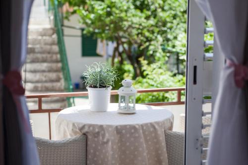 a table with a potted plant on a balcony at Apartments Orka in Promajna