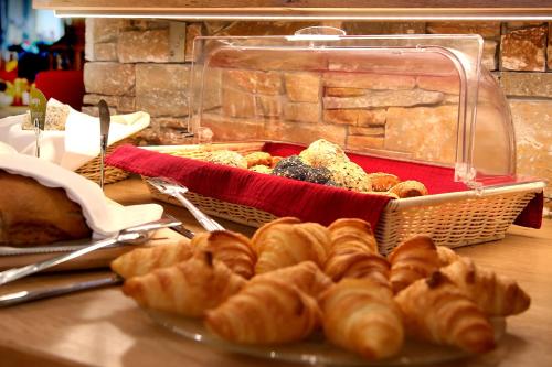 a table with a plate of pastries and a basket of bread at Hotel Eder Michaela in Saalbach Hinterglemm