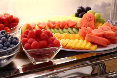 a platter of fruit on a table with a plate at Hotel Eder Michaela in Saalbach Hinterglemm