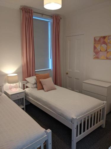 a bedroom with two beds and a window at Glenclova - No 5 Bellyeoman, bright two bedroom apartment in Fife