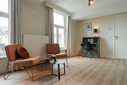 a living room with two chairs and a table at B&B Tannerie in Balen
