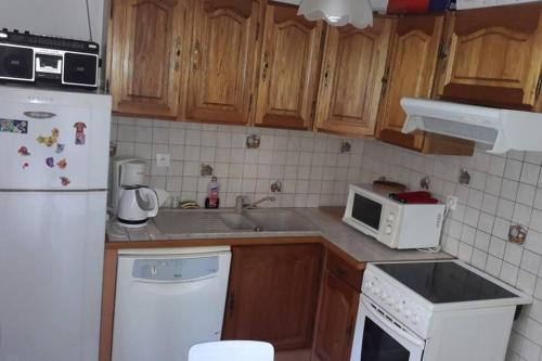 La cuisine est équipée d'un réfrigérateur et d'un four micro-ondes blancs. dans l'établissement appartement 6 personnes au coeur de super besse, à Besse-et-Saint-Anastaise