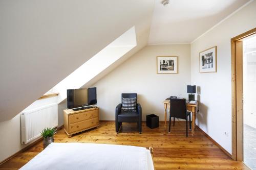 a bedroom with a bed and a desk and chairs at Il Plonner - Hotel Restaurant Biergarten in Weßling