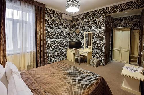 a bedroom with a bed and a desk with a computer at Прага in Krasnodar