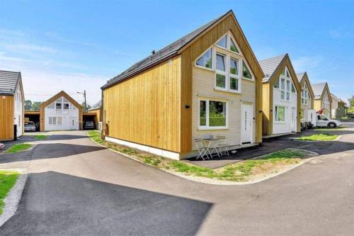 a wooden house with a car parked in a driveway at Nybygd feriebolig rett ved strand til leie! in Kristiansand