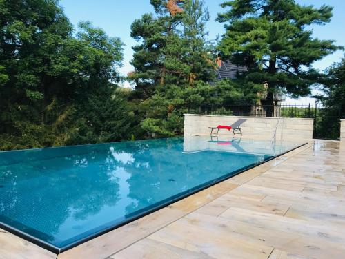 a swimming pool with a red chair sitting next to it at Schlosshotel Stecklenberg in Thale