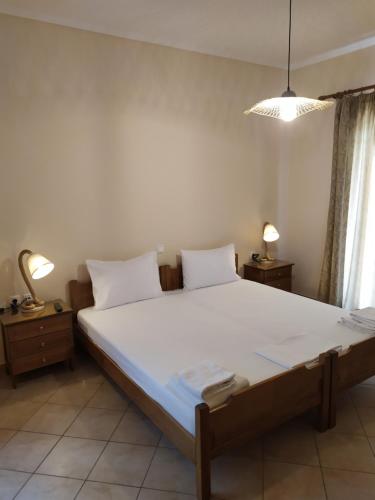 a bedroom with a large bed with white sheets and pillows at Katsenos studios in Nikiana