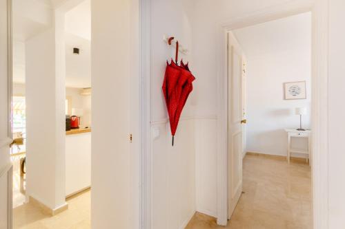 un paraguas rojo colgado en una pared en un pasillo en Apartamento Confortable Urbanización El Paraiso, en Estepona