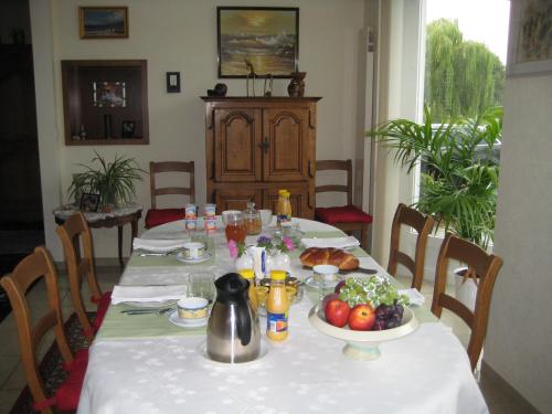 a table with a white table cloth with food on it at Les Petites Chambres de la Bleue Maison in Coeuve