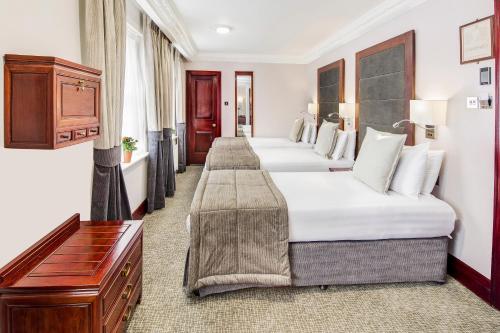 a row of beds in a hotel room at Gem Fitzrovia Hotel in London