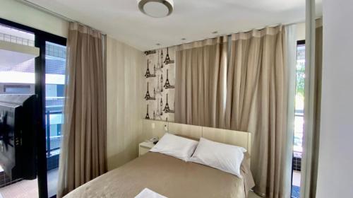 a bedroom with a bed and a large window at Landscape Beira-Mar Perfect in Fortaleza
