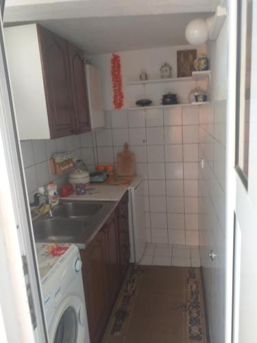a small kitchen with a sink and a washing machine at Guesthouse Djacic in Budva