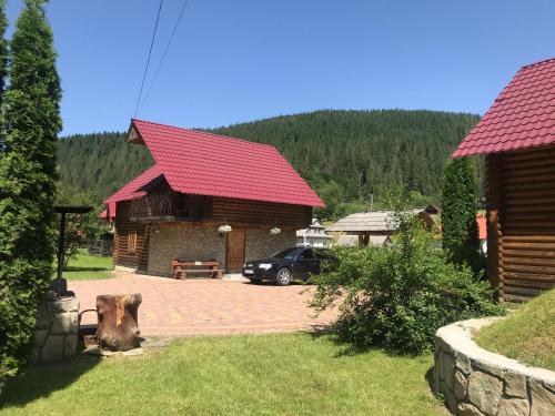a house with a car parked in front of it at Садиба "Джерело" in Yaremche