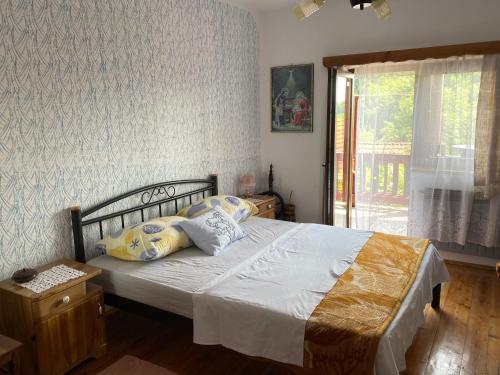 une chambre avec un lit avec des oreillers et une fenêtre dans l'établissement Villa Mirela, à Maretić