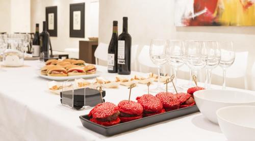 a table with a tray of strawberries and wine glasses at Hotel Plazaola in Irurtzun