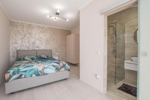 1 dormitorio con 1 cama y ducha a ras de suelo en Apartments Barbara, en Umag
