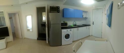 a kitchen with a refrigerator and a washing machine at Hotel Apartment Short Term Tel Aviv Bat Yam 5 in Bat Yam