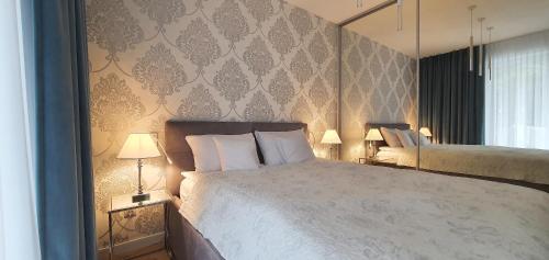 ein Schlafzimmer mit einem großen Bett und zwei Lampen in der Unterkunft Apartement Insel Usedom Swinemünde in Świnoujście