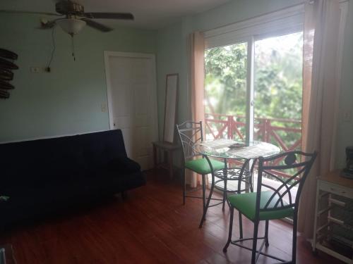 a living room with a table and chairs and a window at Caribbean Villages Aparments in Bocas del Toro