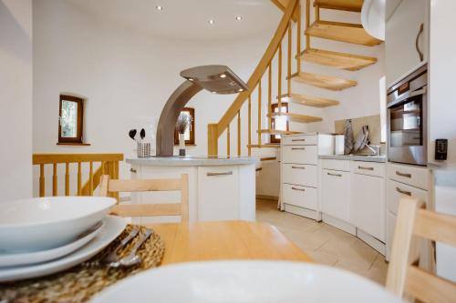 uma cozinha e sala de jantar com uma escada em espiral em Ferienwohnung Wasserturm Thale em Thale