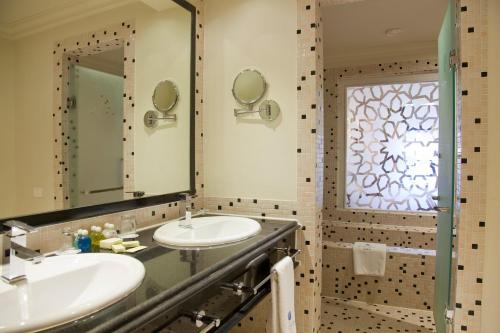 a bathroom with two sinks and a window at The Makadi Spa Hotel - Couples Only 18 Years Plus in Hurghada
