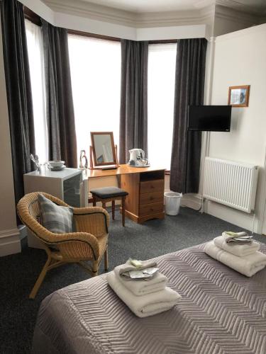 a hotel room with two beds and a chair at Fairways Guest House in Cambridge