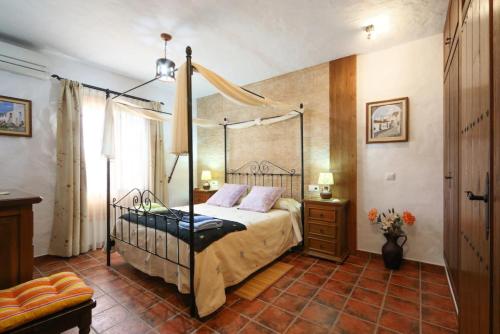 ein Schlafzimmer mit einem Bett mit einem Metalldach in der Unterkunft Casa Las Piedras in Frigiliana