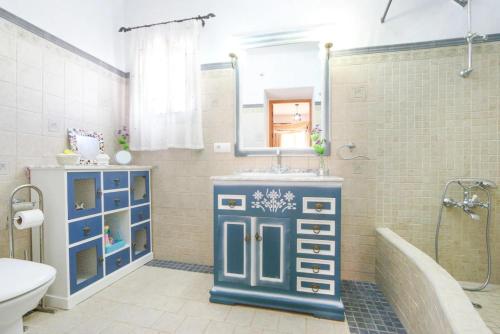 baño con armario azul y lavamanos en Casa Las Piedras, en Frigiliana