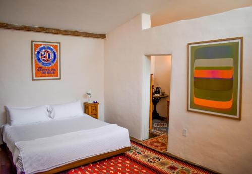 a bedroom with a white bed and a painting on the wall at The Parador in Santa Fe