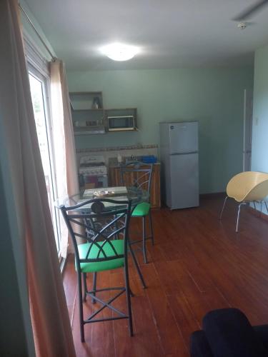 a kitchen with a table and chairs and a refrigerator at Caribbean Villages Aparments in Bocas del Toro