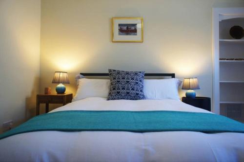1 dormitorio con 1 cama blanca grande y 2 lámparas en 17 William Street, en Helensburgh