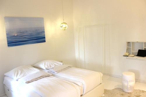 um quarto branco com uma cama com uma fotografia na parede em Shared a-partment • Möbliertes Zimmer in Köln - Ehrenfeld ! em Colônia
